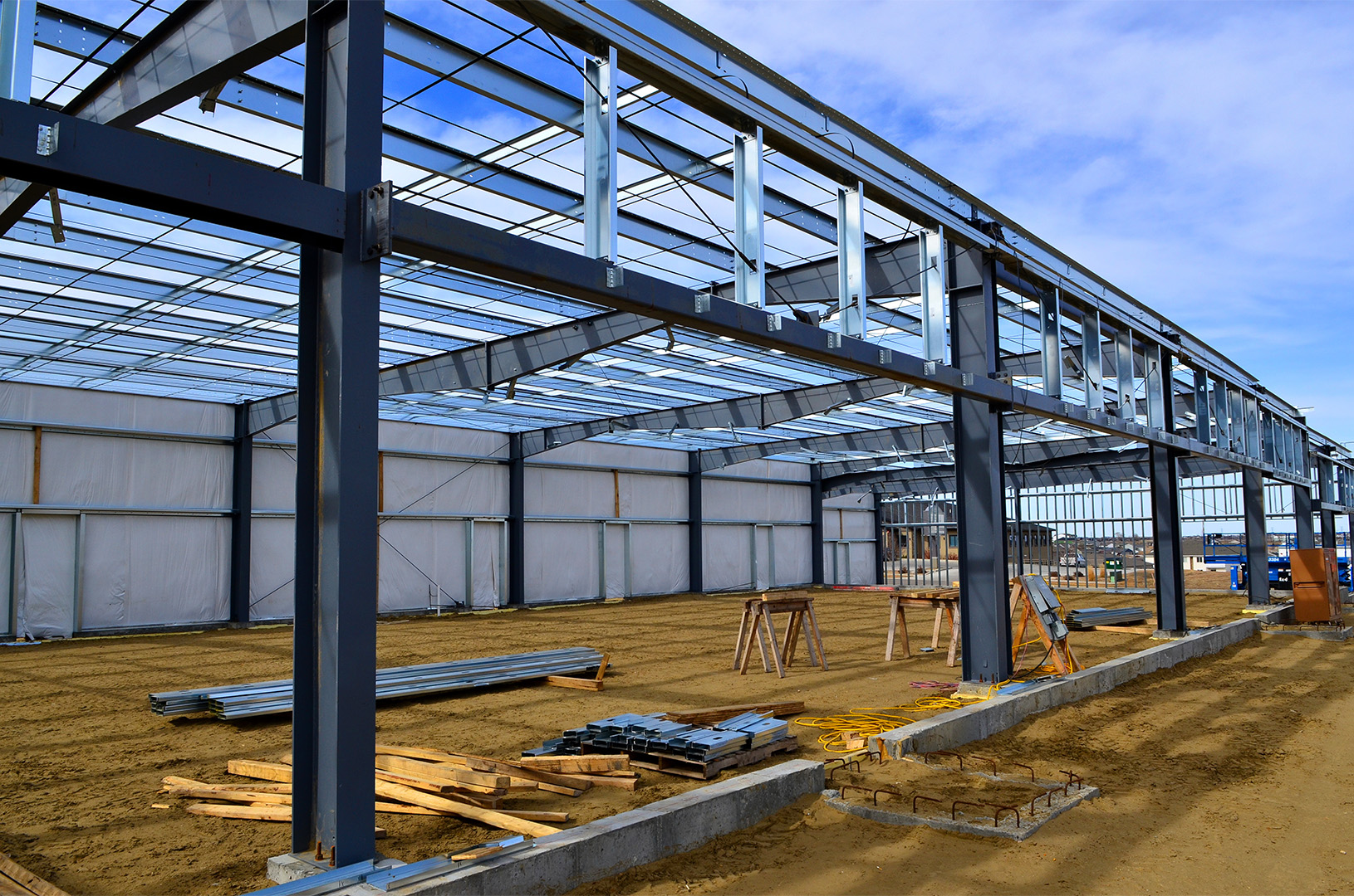 Steel frame of a large building under construction on a former industrial site