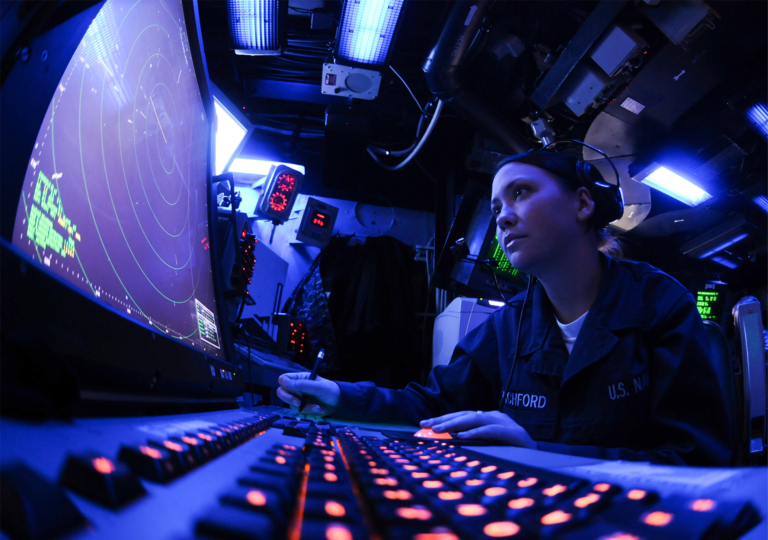 Military personnel looking at a radar screen