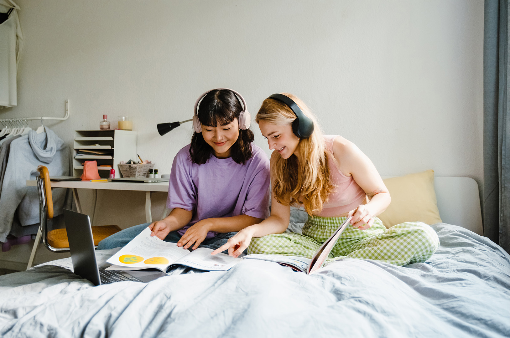 Two friends studying together in a bedroom