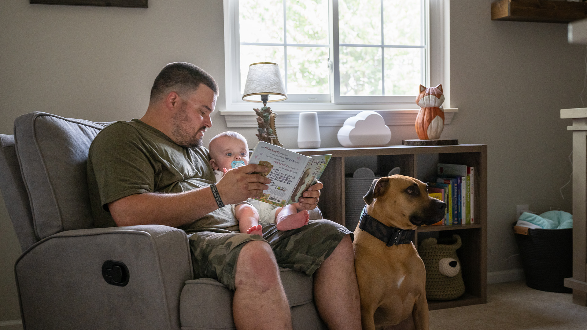 Father reading a book to infant son in their home