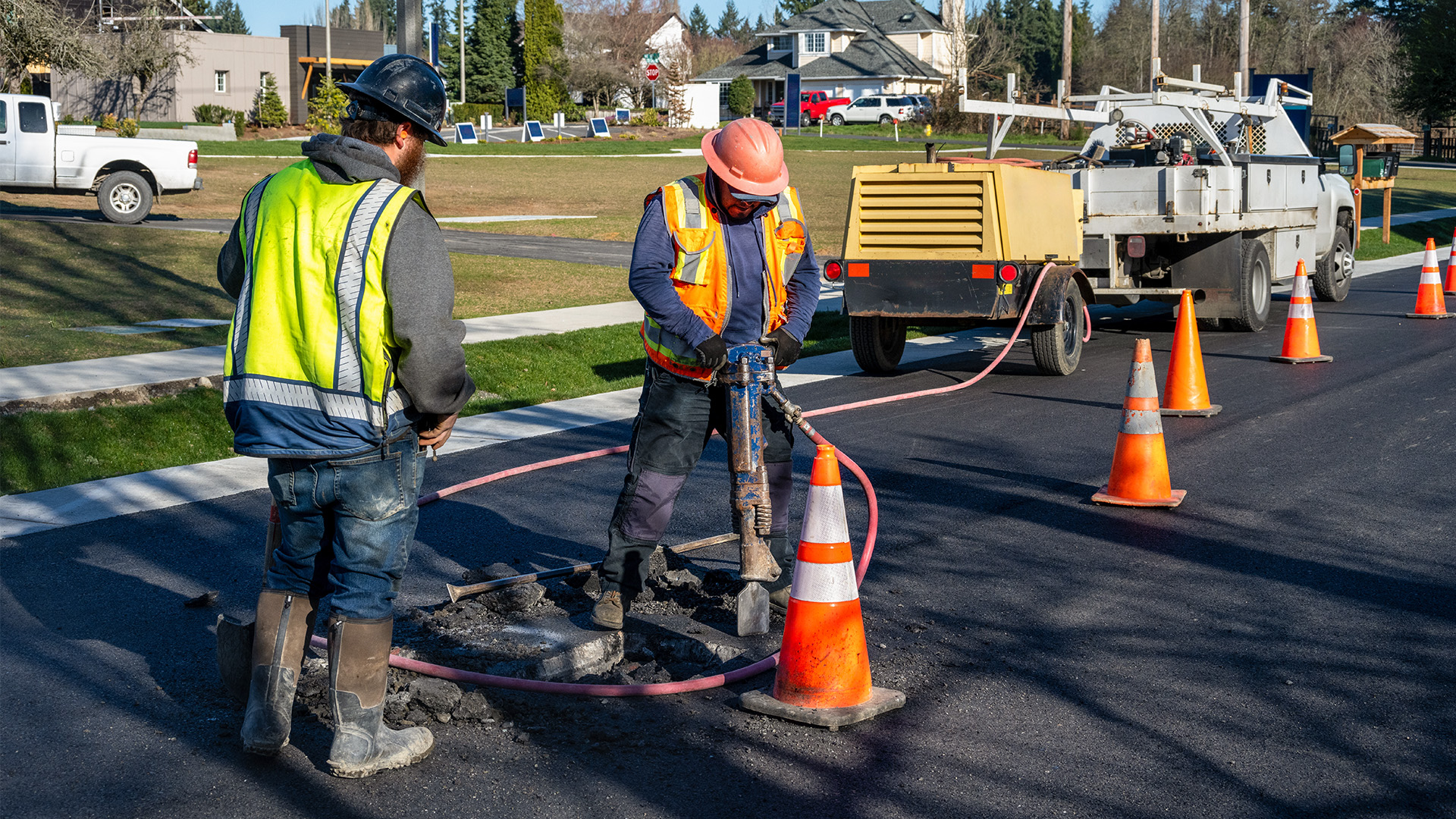 Construction workers fixing a pothole in a local road